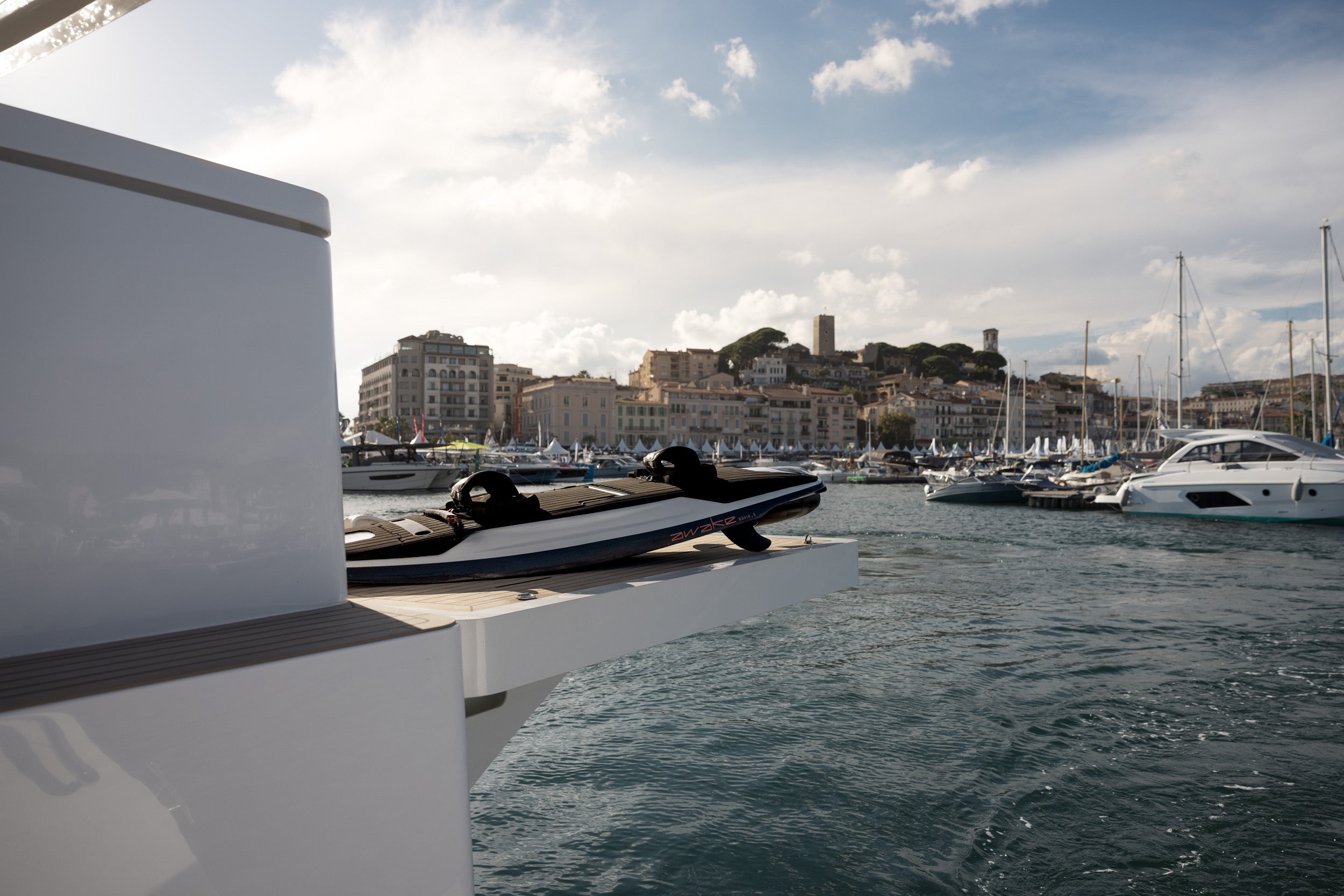 Awake Electric Surfboard Ravik S on SIlent Yacht raised deck with Cannes harbour in the background.