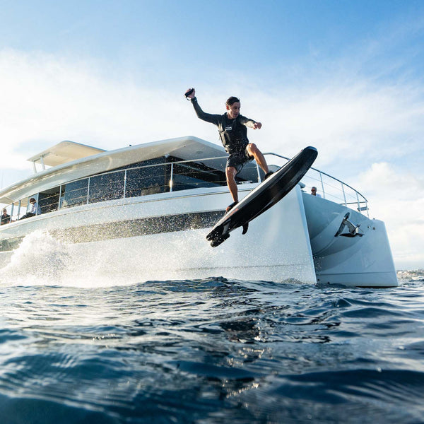 A man makes a jump on the ravik S in front of a yacht.